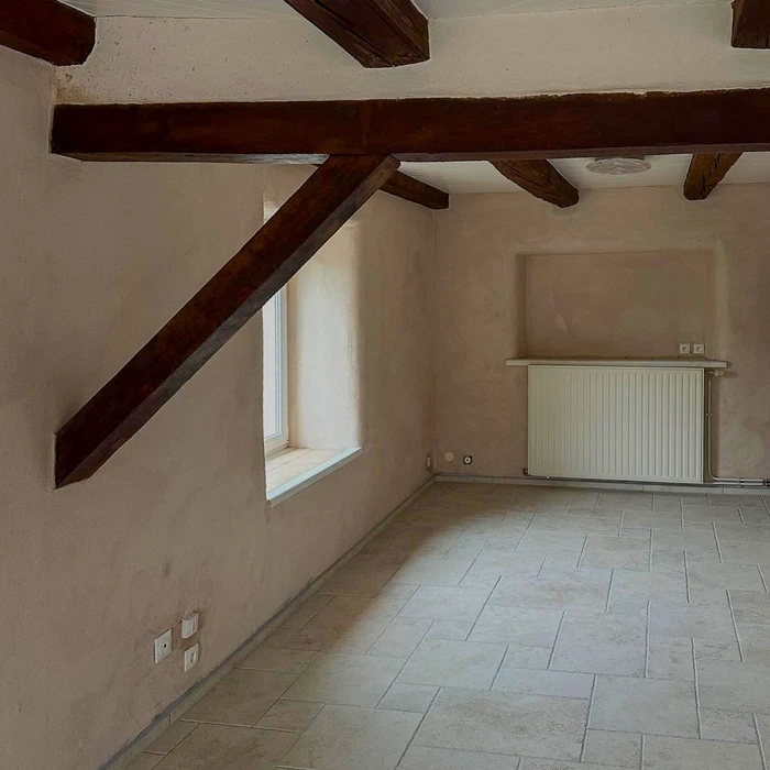 Facade latérale d'une maison individuelle de plain-pied, enduit blanc lisse avec chaîne d'angle en pierre reconstituée apparente