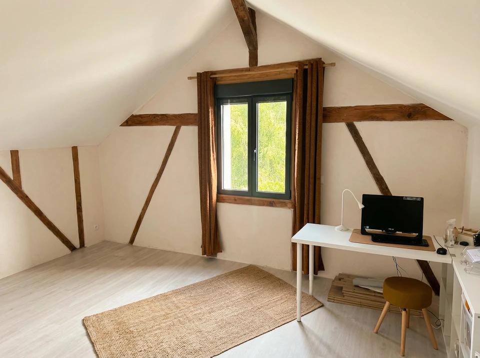 Intérieur d'une maison en construction avec charpente bois apparente et isolation thermique entre montants
