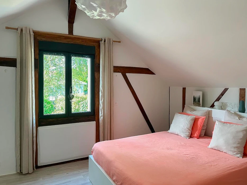 Chantier de rénovation intérieure, pièce vide avec murs en pierre apparente et fenêtres à petits carreaux