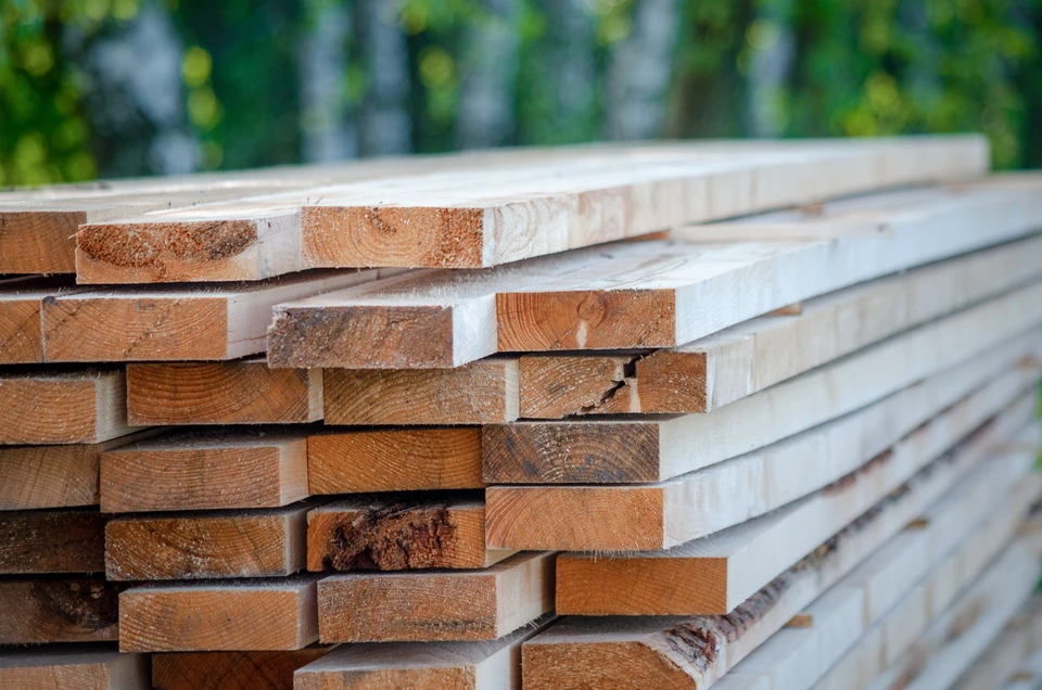 Extérieur, pile de planches en bois brut empilées horizontalement, essence claire type pin ou sapin