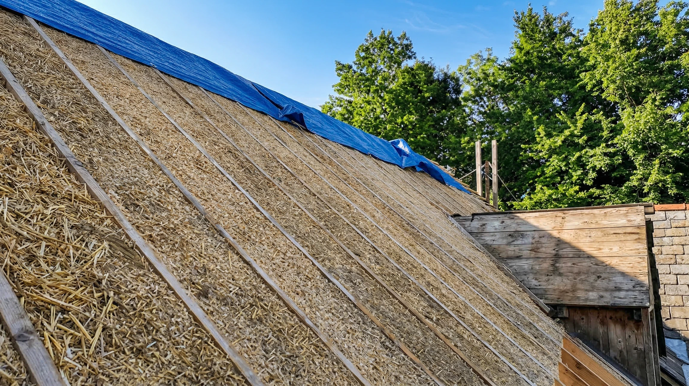 Personne en chemise blanche manipulant un rouleau d'adhésif isolant gris argenté à deux mains dans un environnement intérieur lumineux