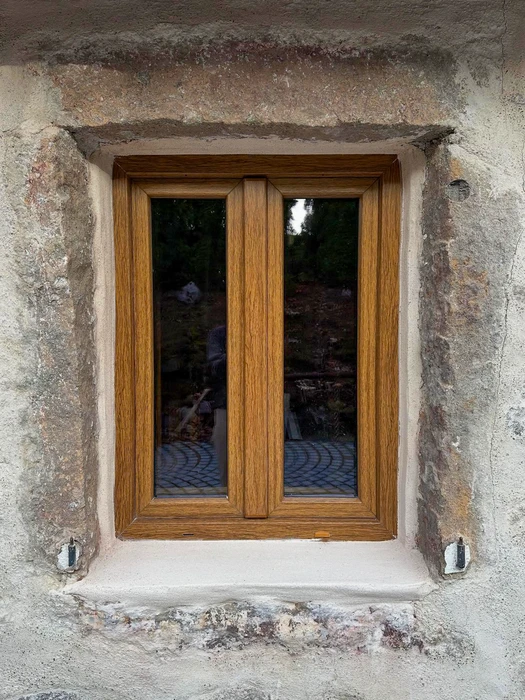 Façade extérieure d'une maison neuve à deux niveaux, enduit blanc lisse, chaîne d'angle en pierres de taille apparentes