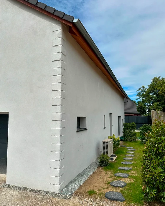 Façade en pierre naturelle apparente d'un bâtiment rénové, vue en contre-plongée