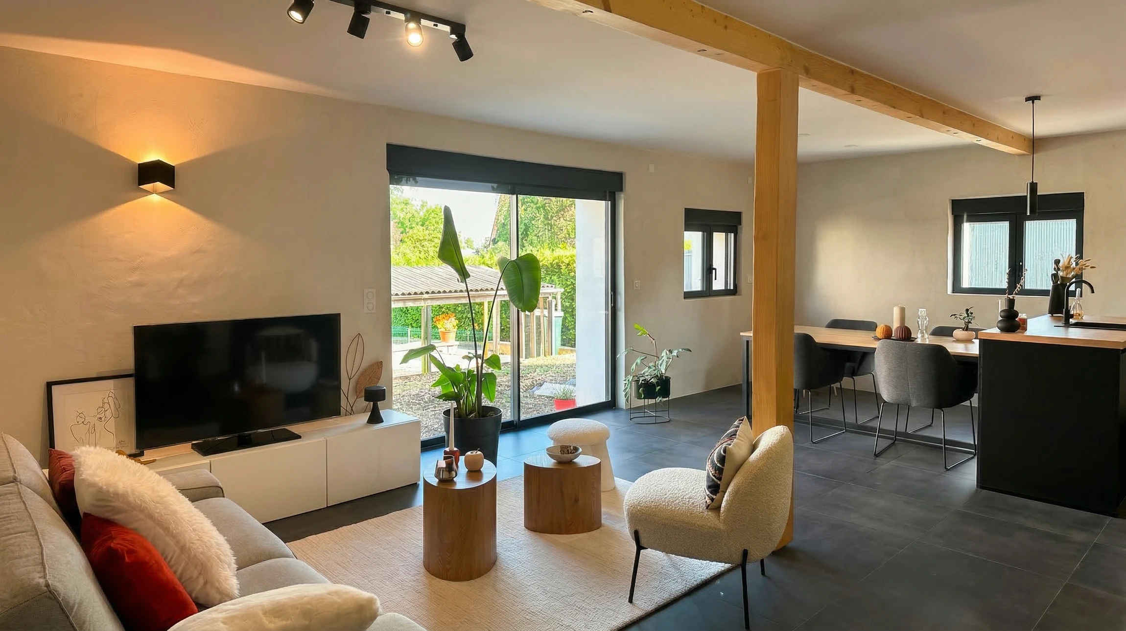 Maison contemporaine &agrave; ossature bois avec bardage en lames horizontales, toiture en ardoises grises &eacute;quip&eacute;e de fen&ecirc;tres de toit et panneau solaire thermique