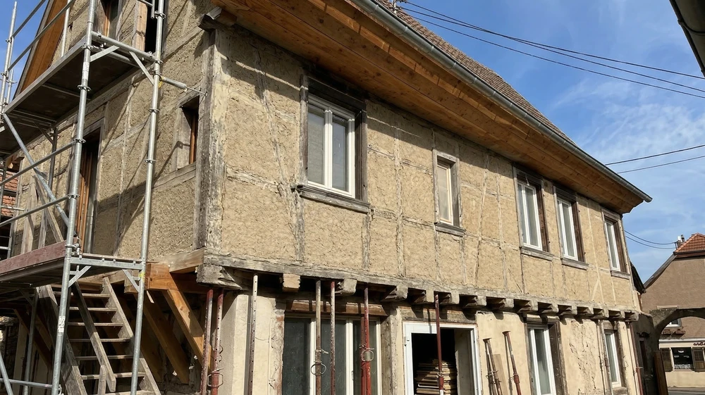 Façade en pierre naturelle apparente d'un bâtiment rénové, vue en contre-plongée